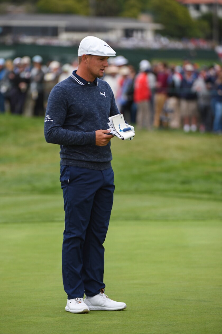 Bryson DeChambeau consulting his green book