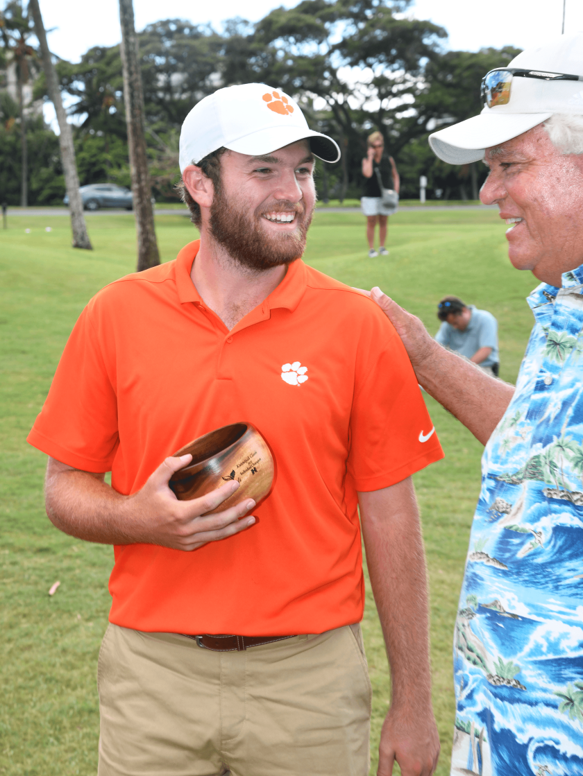 Clemson's Andrew Swanson (left) receives the individual trophy from University of Hawai'i Men's Golf Coach, Scott Simpson.png